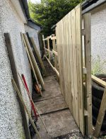 fence in process of being built beside garage